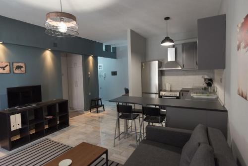 a kitchen and living room with a couch and a table at Centrally Located Apartment in Volos