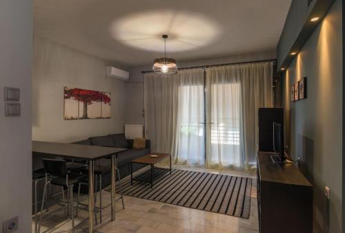 a living room with a dining room table and a couch at Centrally Located Apartment in Volos