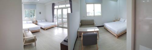 a room with two beds and a table and a chair at Ta Li Wen B&B in Zhushan