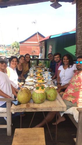 a group of people sitting around a table with food at ST 63 Home Stay & Tour Kampong Khleang in Kâmpóng Khleăng