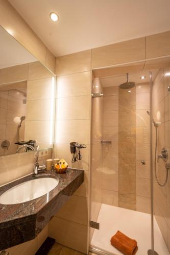 a bathroom with a sink and a shower at Boutique Hotel Angerer in Murnau am Staffelsee