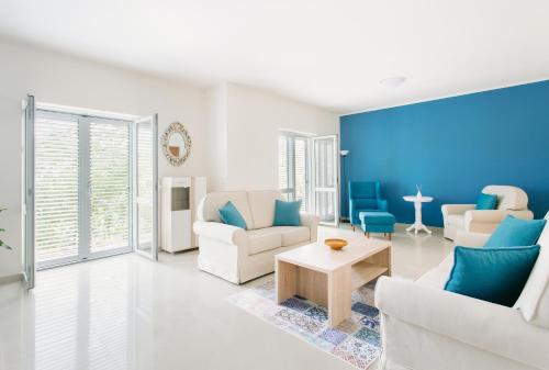 a living room with white furniture and blue walls at Villa Sladovic in Herceg-Novi