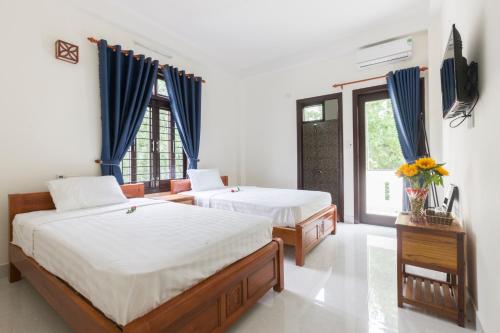- une chambre avec 2 lits et une fenêtre dans l'établissement New Destination Hoi An, à Hội An