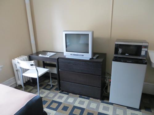 サンフランシスコにあるホテル ノース ビーチのテレビ、デスク、コンピュータが備わる客室です。