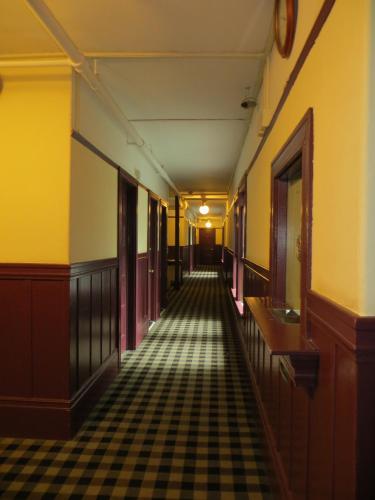 an empty hallway in an old building with a checkered floor at Hotel North Beach in San Francisco