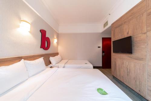 a hotel room with two beds and a flat screen tv at Hotel Bencoolen Singapore in Singapore