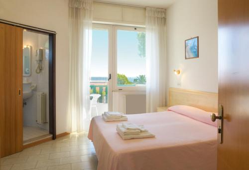 sypialnia z łóżkiem i ręcznikami w obiekcie Hotel K2 w mieście Numana