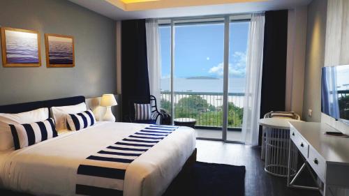 a bedroom with a large bed and a large window at Swiss-Belresort Belitung in Tanjungbinga