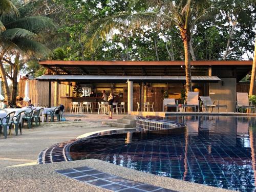 a resort with a swimming pool and a restaurant at Noble House Beach Resort in Ko Lanta