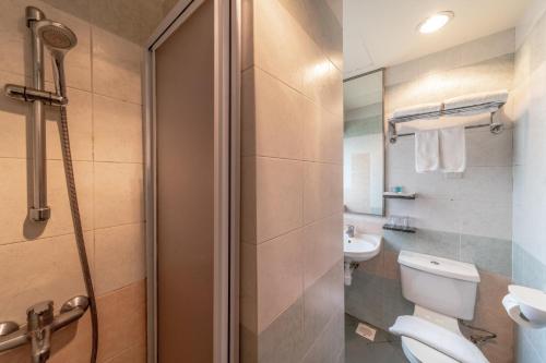 y baño con aseo, lavabo y ducha. en Hotel Bencoolen Singapore en Singapur