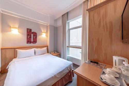 a hotel room with a bed and a window at Hotel Bencoolen Singapore in Singapore