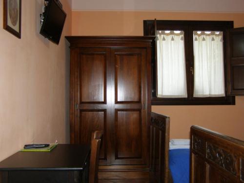 a room with a wooden cabinet and a table and a window at B&B Le Grazie in Piaggine