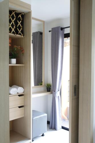 a walk in closet with a window and a curtain at Bangkok Boutique Resort Rangsit in Pathum Thani