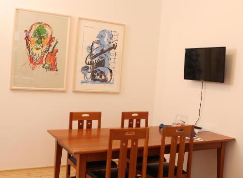 a dining room table with chairs and a television at Haus Roy in Zülpich