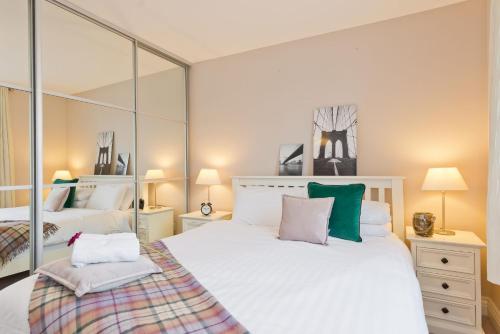 Un dormitorio con una gran cama blanca y espejos en Broc House Suites, en Dublín