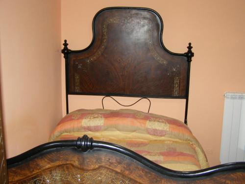a bed with a wooden head board in a room at B&B Le Grazie in Piaggine