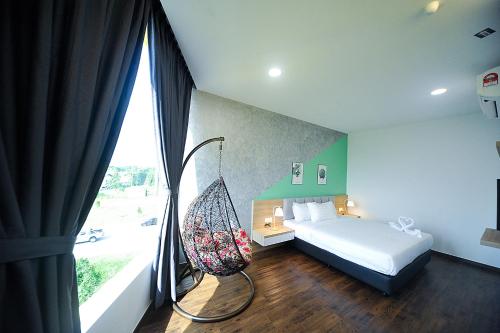 a bedroom with a bed and a swing next to a window at MYe Hotel in Muar
