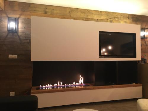 韋爾比耶的住宿－Verbier Medran + Private Sauna，客厅设有壁炉,上面配有电视