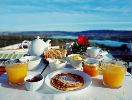 a table with a breakfast of pancakes and orange juice at Casa Campana in Arcos de la Frontera