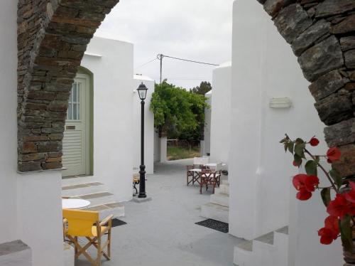 a courtyard with white walls and tables and chairs at Giannakas Studios in Platis Yialos Sifnos