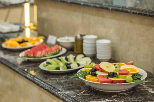 a buffet with plates of fruit on a table at Roy Dala Hotel in Da Lat