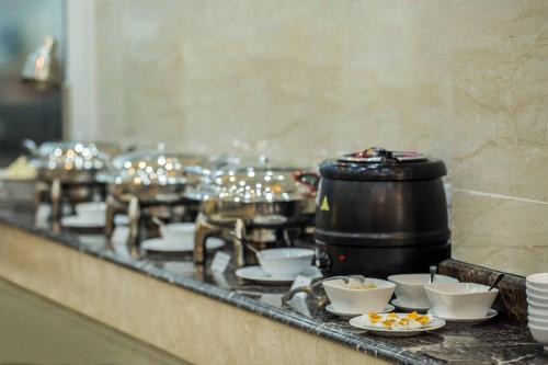 a row of bowls and cups on a counter with food at Roy Dala Hotel in Da Lat