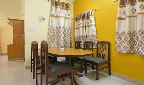 ein Esszimmer mit einem Holztisch und Stühlen in der Unterkunft Itsy By Treebo - Shivas Kuteera in Bangalore