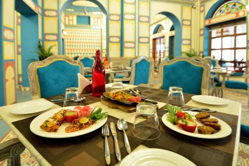 a table with two plates of food on it at Nirbana Palace - A Heritage Hotel and Spa in Jaipur