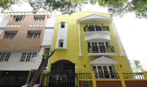 ein gelbes Gebäude mit zwei Balkonen darauf in der Unterkunft Itsy By Treebo - Shivas Kuteera in Bangalore