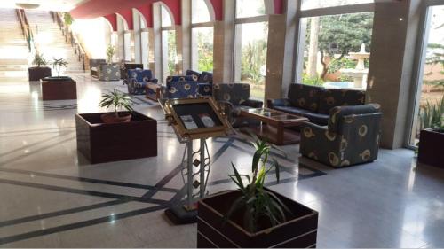 a lobby with chairs and a table and plants at Hotel Mazafran in Zeralda