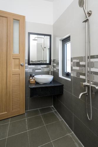 une salle de bain avec un lavabo et une douche dans l'établissement Fuji Hostel, à Đà Nẵng
