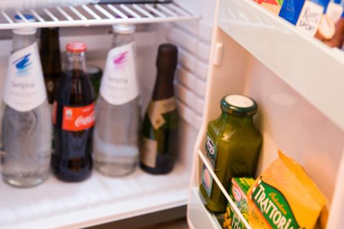 a refrigerator filled with bottles of alcohol and food at Style Hotel Grifone in Madonna di Campiglio