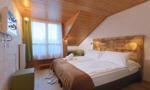 a bedroom with a large bed and a window at Style Hotel Grifone in Madonna di Campiglio