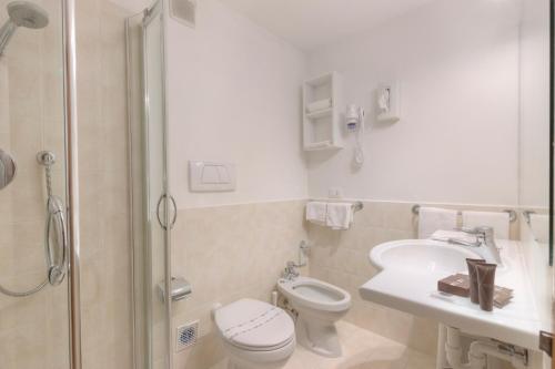 a bathroom with a toilet and a sink and a shower at Style Hotel Grifone in Madonna di Campiglio