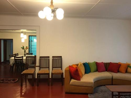 - un salon avec un canapé et des oreillers colorés dans l'établissement HangarankandaBungalow Deniyaya, à Deniyaya