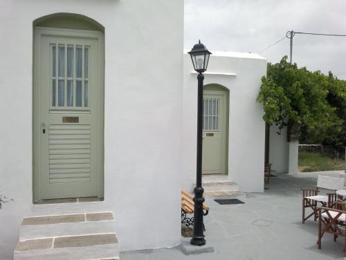 a white building with green doors and a street light at Giannakas Studios in Platis Yialos Sifnos