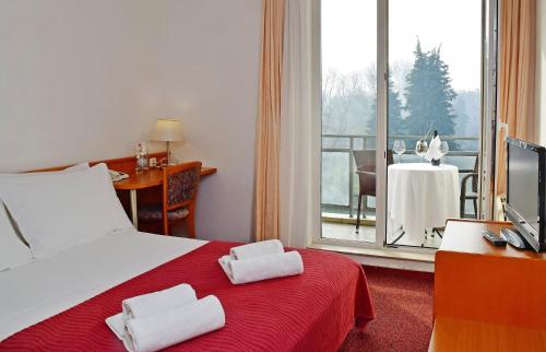 a hotel room with a bed with towels on it at Hotel Alkar in Sinj