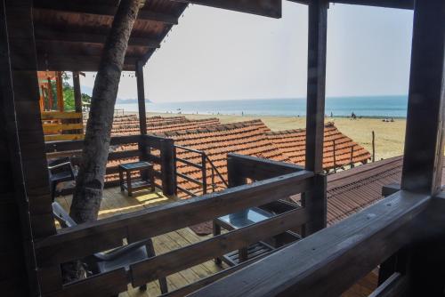 a view of the beach from the deck of a beach house at Agonda Paradise in Agonda