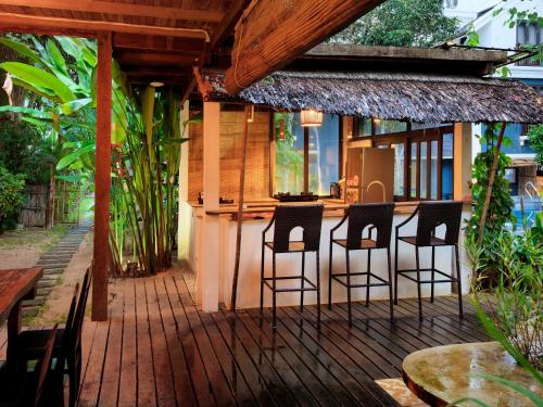 a patio with chairs and a bar in a house at AIRA Boutique Hoi An Hotel & Villa in Hoi An