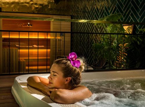 a young girl sitting in a bath tub at Hotel Brown Beach House & Spa in Trogir