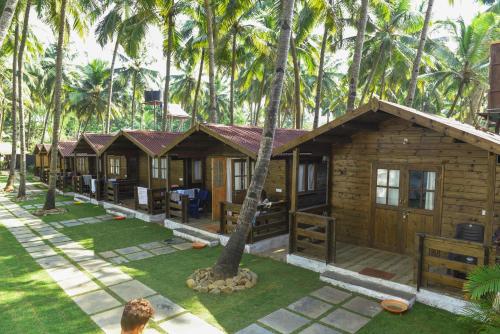 a row of cottages in the middle of palm trees at Agonda Paradise in Agonda