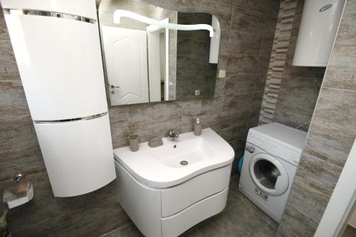 a bathroom with a sink and a washing machine at Kate Apartments in Ohrid