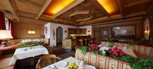 a restaurant with tables and chairs with flowers on them at Pension Hohenrainer in Reutte