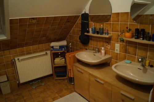 a bathroom with two sinks and a mirror at Gemütliches Zimmer zentral in der Lüneburger Heide in Schneverdingen