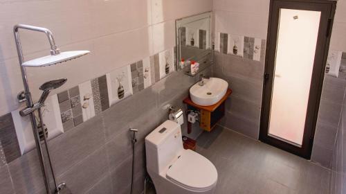 a bathroom with a toilet and a sink at Hugo Homestay in Phong Nha