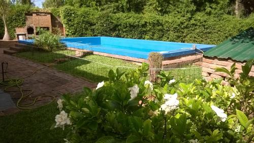 una piscina en un patio con flores blancas en Quinta La Verde en 