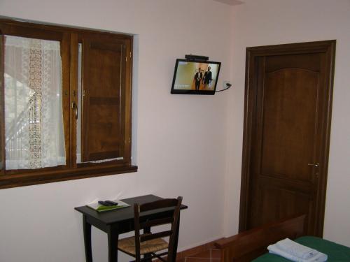 a room with a table and a window with a picture on the wall at B&B Le Grazie in Piaggine