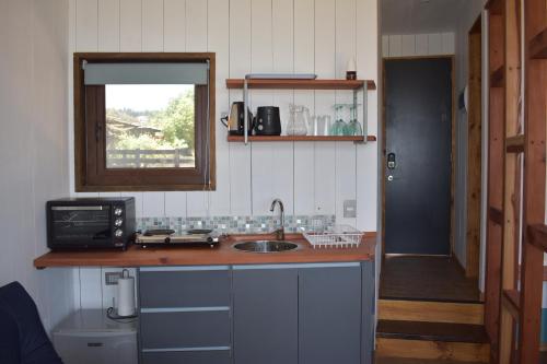 a kitchen with a sink and a counter with a window at Morros del Pacífico in Pichilemu