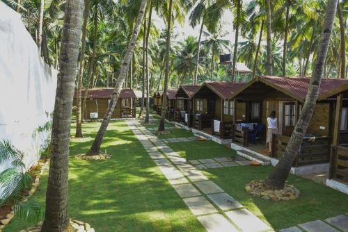 a row of cottages in the middle of palm trees at Agonda Paradise in Agonda