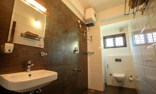 un baño con lavabo e inodoro en Falcon Suites Yelahanka New Town, en Bangalore